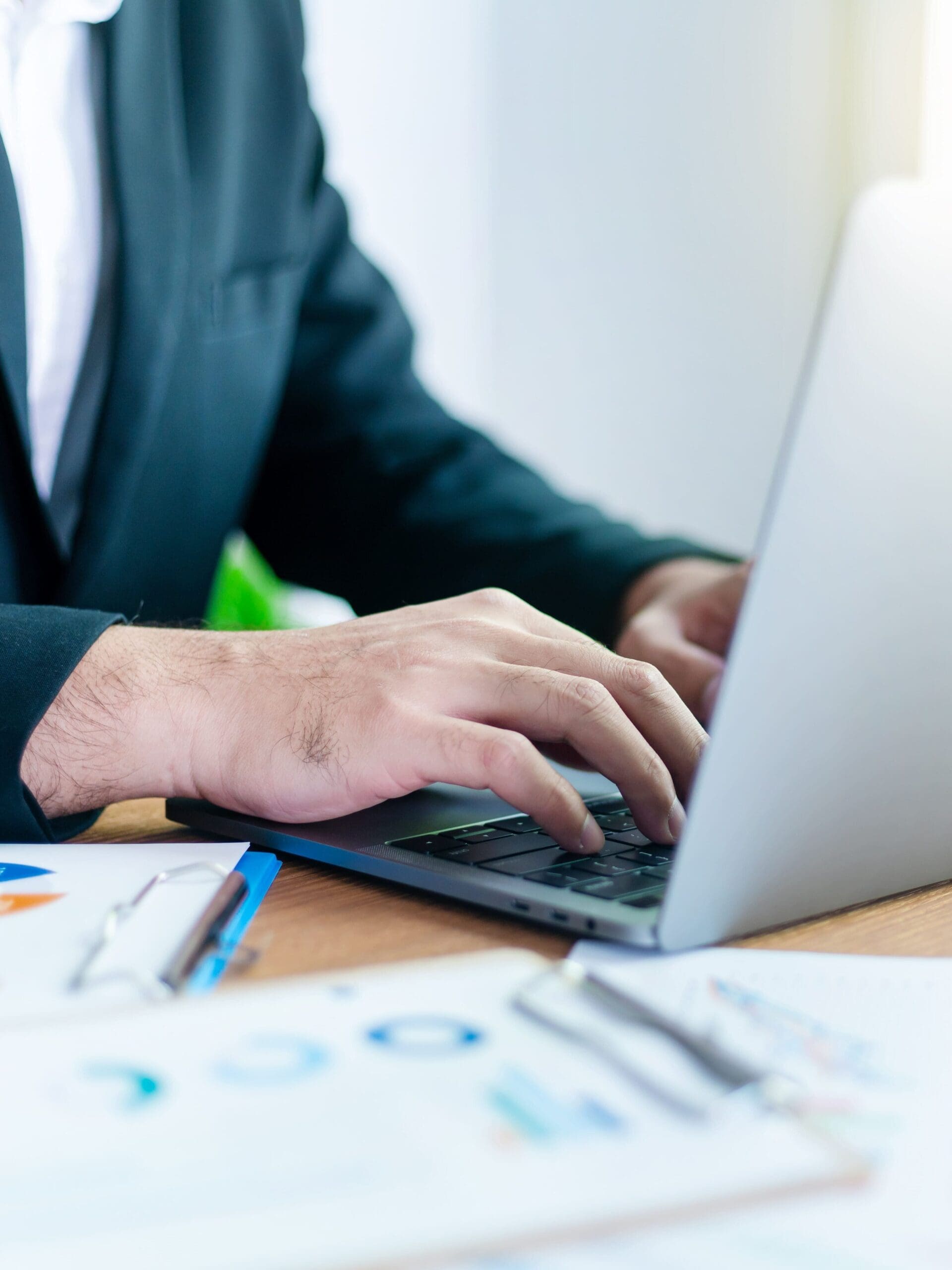 A CPA at a laptop and surrounded by papers, performing small business valuation services in Central PA
