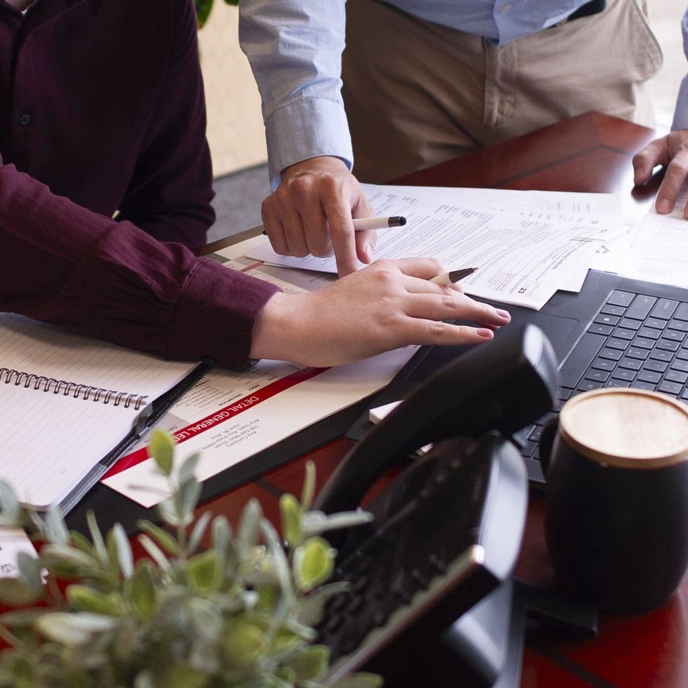 man and woman working on paperwork and laptop in an office