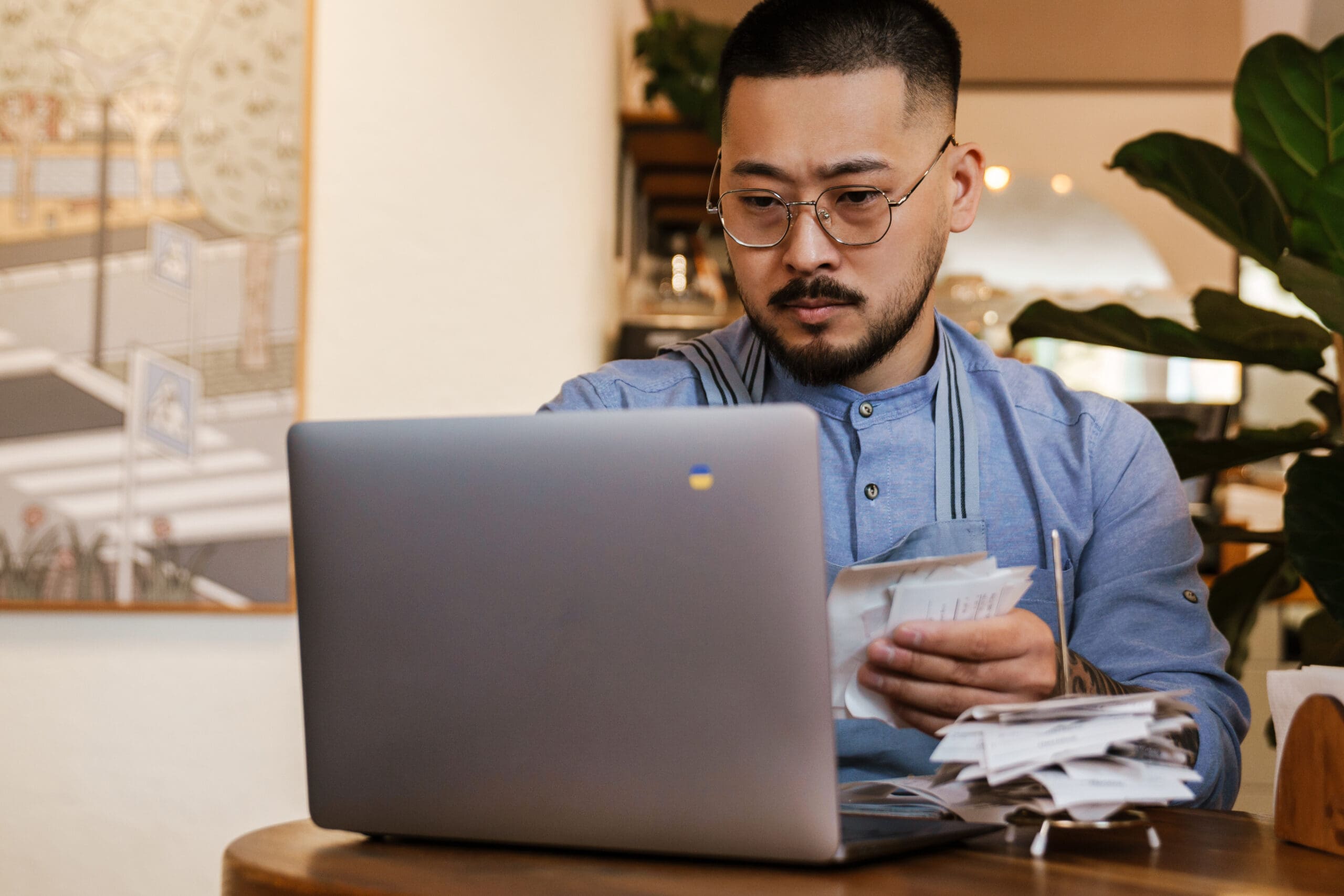 Business owner working with bills while sitting in cafe