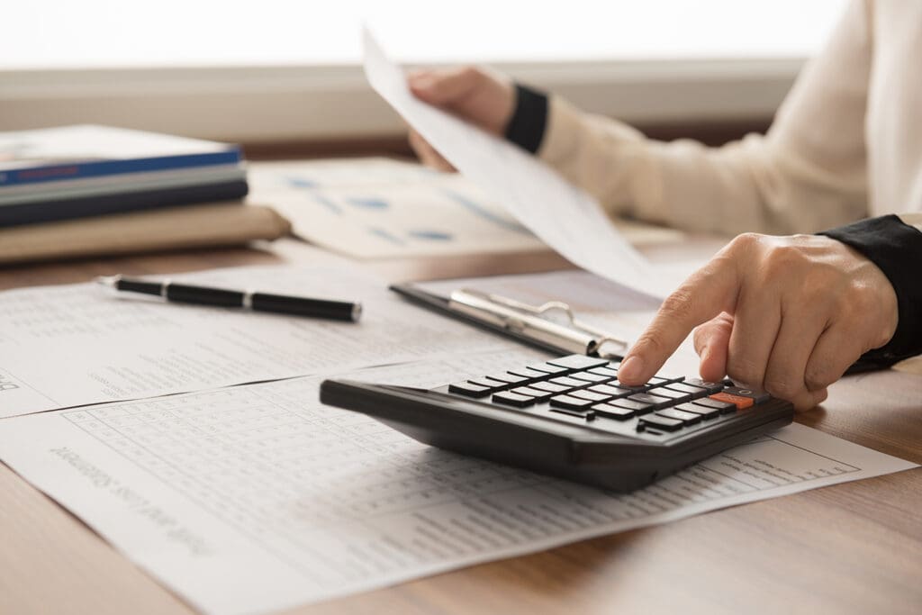 A male CPA working with a calculator and documents.