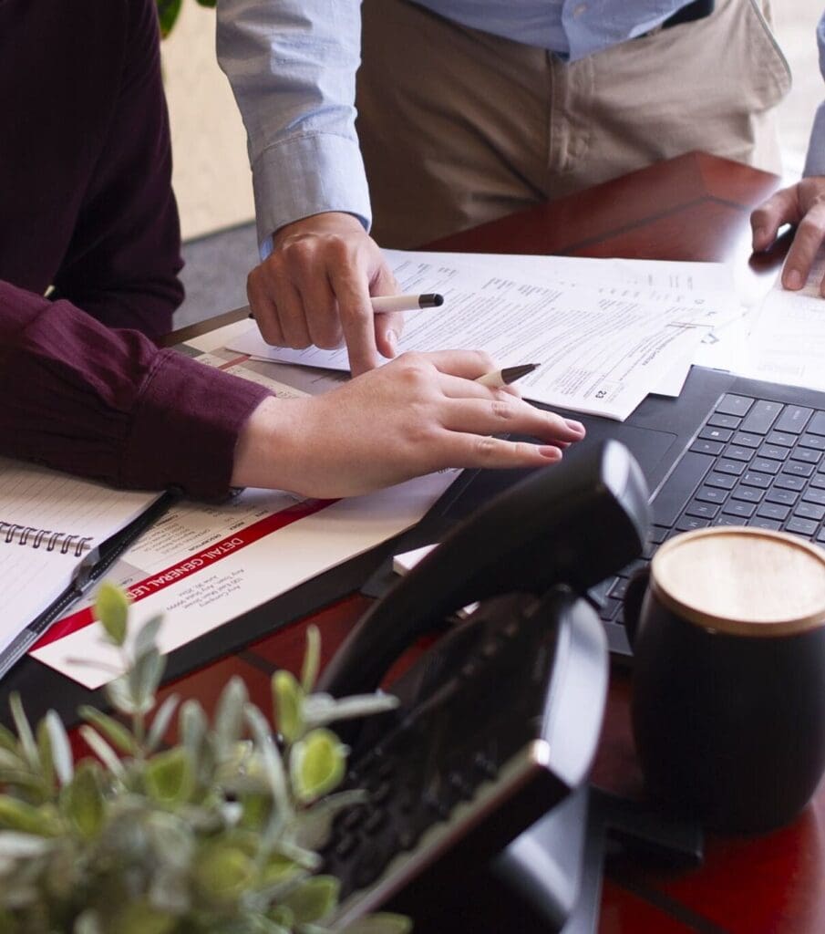 man and woman working on paperwork and laptop in an office
